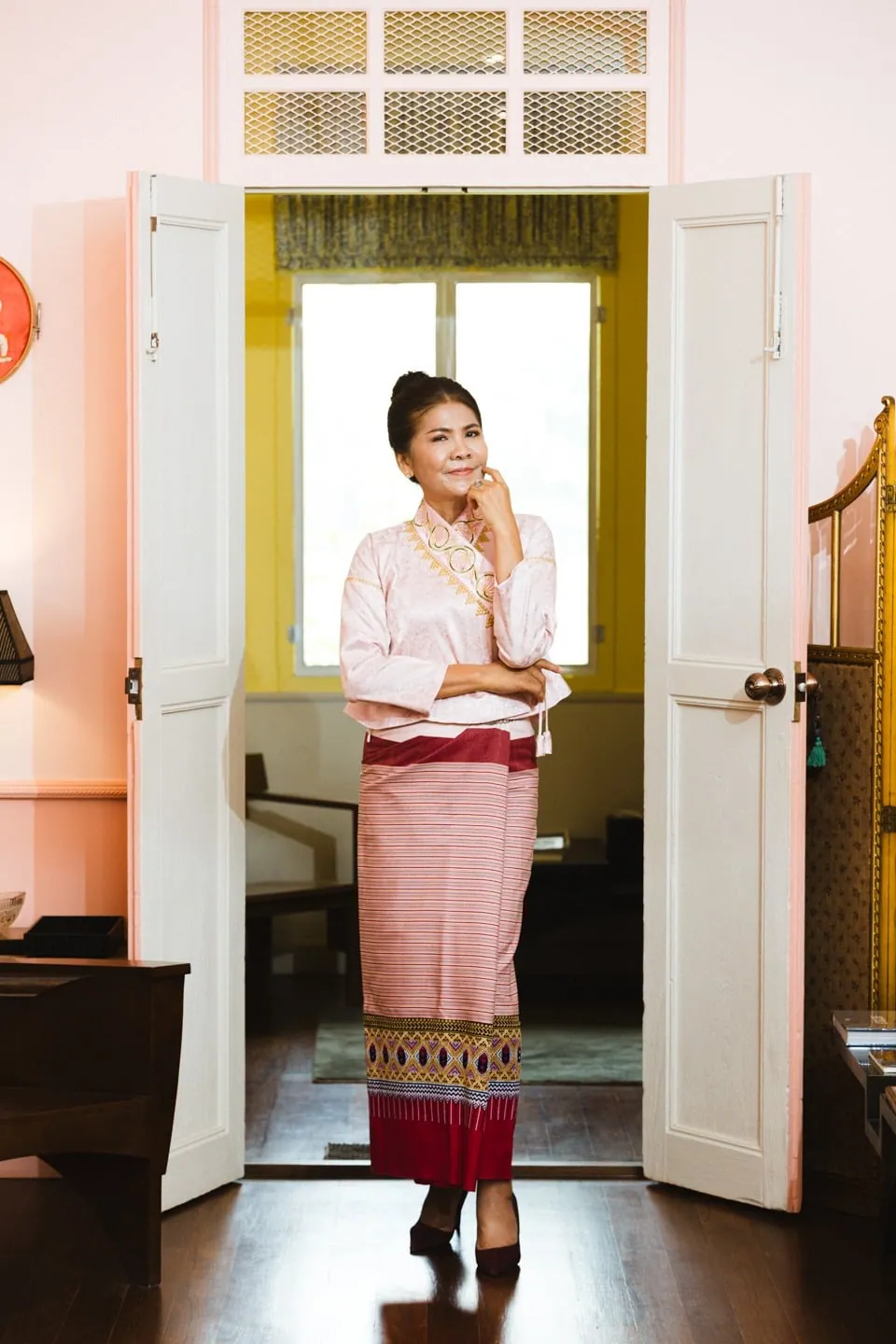 Mrs. Phitsamai wearing a handwoven Thai silk skirt in a heritage home